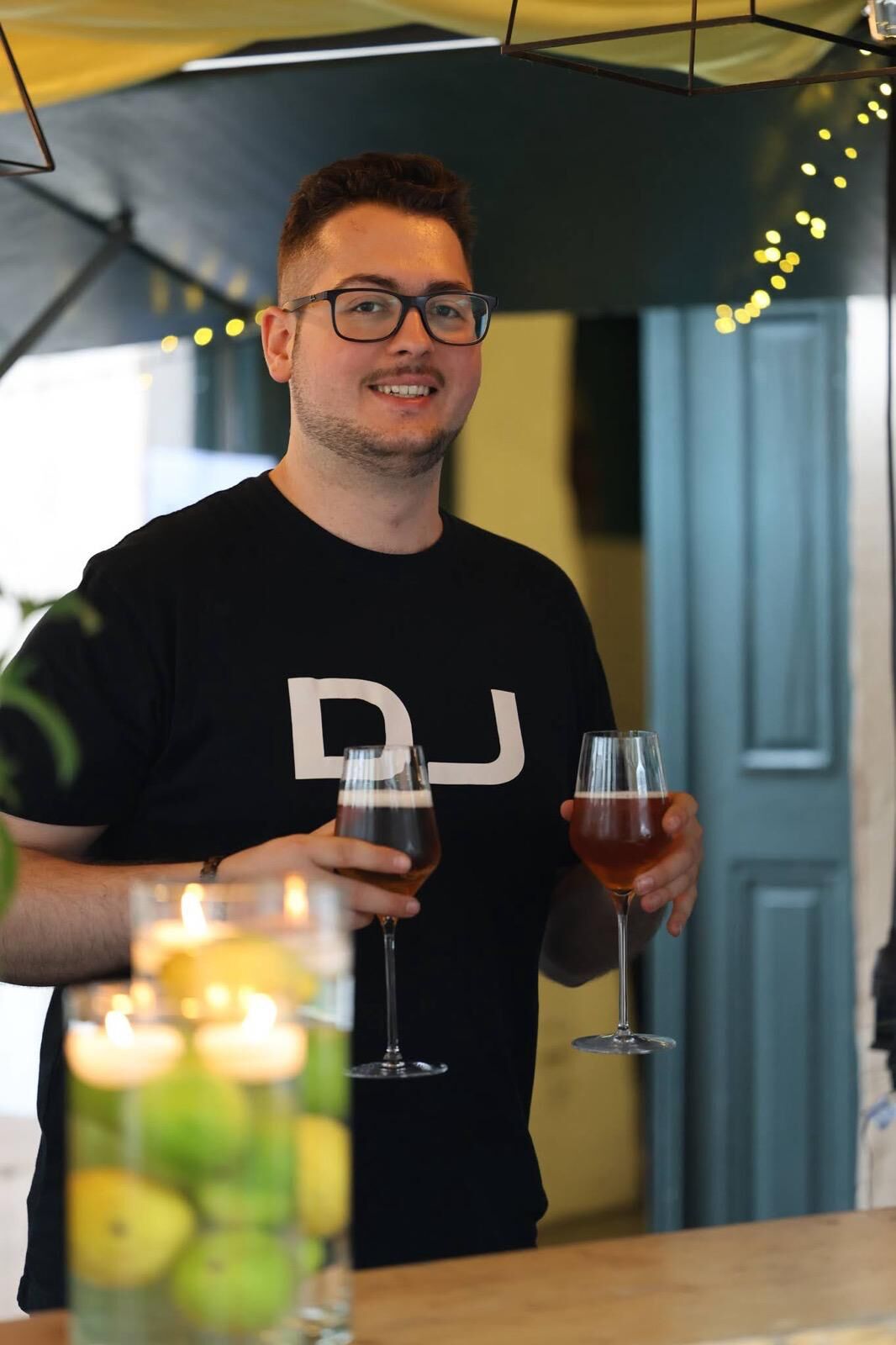DJ Kim Schehl lächelnd mit einem Glas in der Hand